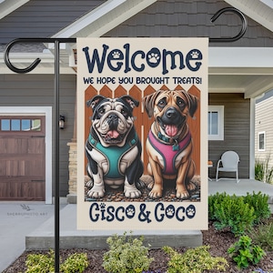 May include: A welcome garden flag with a cartoon image of two dogs, a bulldog and a mastiff, wearing harnesses. The flag has the text "Welcome We hope you brought treats! Gisco & Coco" on it.