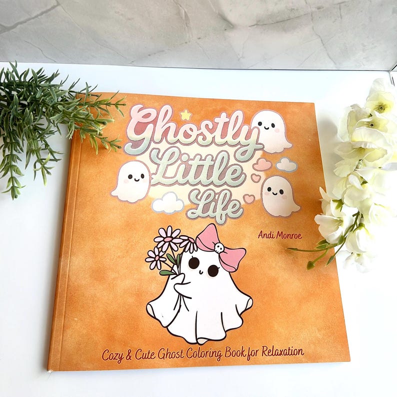 K&ouml;nnte beinhalten: Ein Malbuch mit dem Titel "Ghostly Little Life" mit einem Cartoon-Geist, der Blumen h&auml;lt und eine rosa Schleife tr&auml;gt. Das Cover ist orangefarben mit dem Text "Cozy & Cute Ghost Coloring Book for Relaxation."