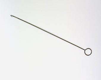 May include: A silver crochet hook with a loop at the end of the handle.