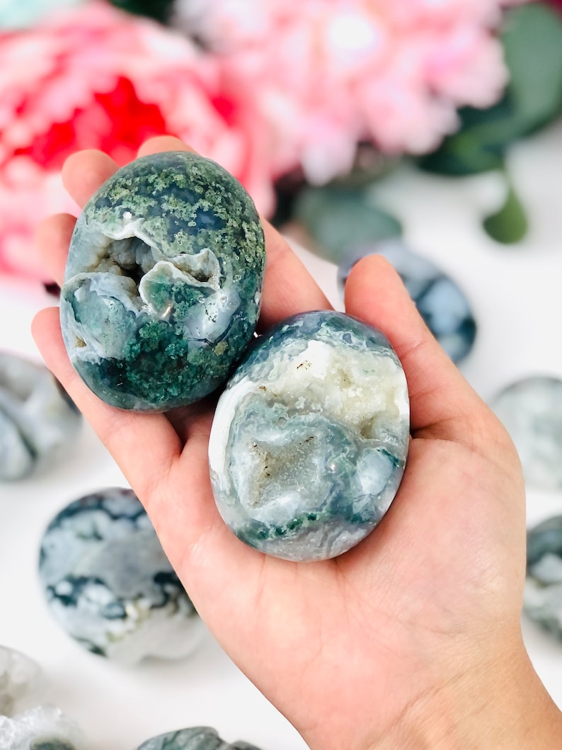Puede incluir: Dos piedras de &aacute;gata verde y blanca con una cueva de cristal en su interior. Las piedras son lisas y pulidas y tienen un aspecto natural y org&aacute;nico.
