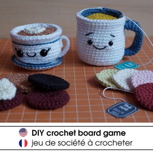 May include: Crocheted coffee cup and teacup with smiling faces, along with crocheted cookies and tea bags. DIY crochet board game, jeu de société à crocheter.