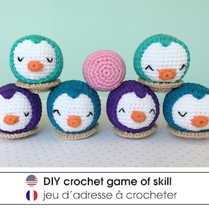 Peut inclure: Un jeu de skill en crochet DIY avec sept pingouins en crochet de couleur violet, turquoise et rose. Les pingouins sont empilés les uns sur les autres, avec une balle rose au milieu. Le texte "DIY crochet game of skill" et "jeu d'adresse à crocheter" est affiché sous l'image.