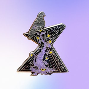 May include: A silver enamel pin featuring a stylized black bird perched on a purple tree with yellow leaves. The pin is shaped like a triangle with the words "PIGEONS PLAYING PING PONG" written on it.