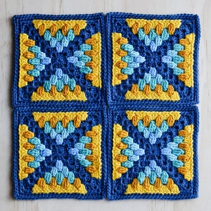 Könnte beinhalten: Vier gehäkelte Quadrate in Blau, Gelb und Türkis. Die Quadrate sind zu einem größeren Quadrat zusammengefügt.