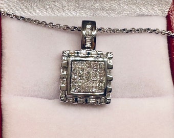 May include: A silver pendant necklace with a square-shaped pendant set with small, clear diamonds. The pendant is surrounded by a decorative border of smaller diamonds.