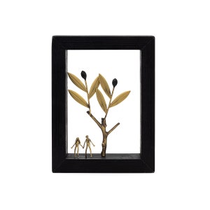 May include: A black framed shadow box with a gold metal olive branch sculpture and two gold metal figures standing beneath it.