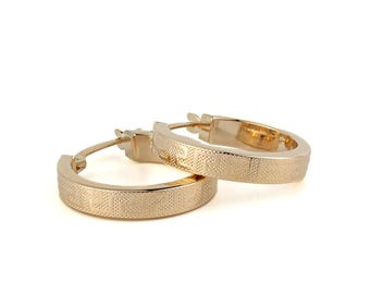 May include: A pair of gold hoop earrings with a textured surface.