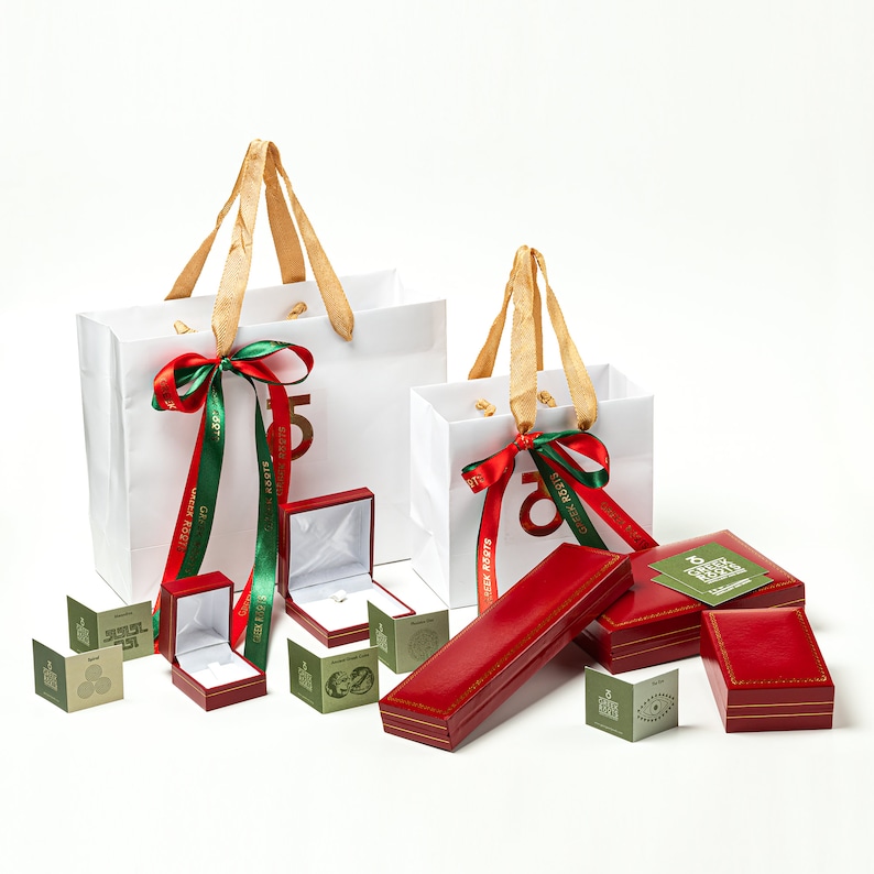 May include: Two white gift bags with red and green ribbon bows. The bags are decorated with the text "50 Years" and "Show Your Love". There are several red and green gift boxes with gold trim and a small green and gold gift tag.