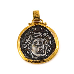 Peut inclure: Un pendentif en or avec une pièce d'argent représentant un profil de visage de femme. La pièce est entourée d'une bordure dorée.