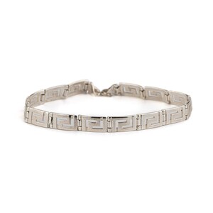 May include: A silver chain bracelet with a geometric pattern.