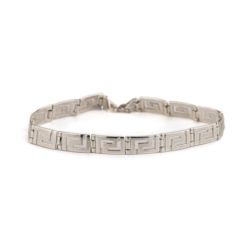 May include: A silver chain bracelet with a geometric pattern.