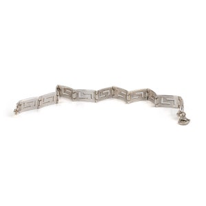 May include: A silver bracelet featuring a geometric pattern. The bracelet is made up of interlocking links that create a repeating design.