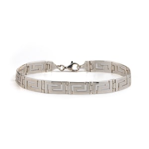 May include: A silver bracelet with a Greek key pattern.