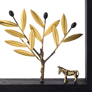 May include: A gold metal olive tree sculpture with black olives and a gold metal donkey sculpture on a black wooden base.