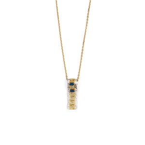 Peut inclure: Un collier en cha&icirc;ne dor&eacute;e avec un pendentif en argent orn&eacute; d'un motif g&eacute;om&eacute;trique et de pierres pr&eacute;cieuses bleues.