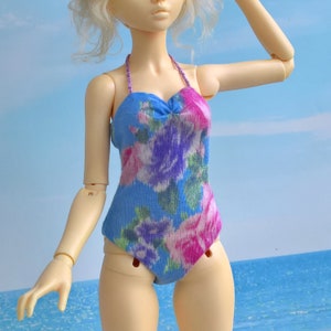 May include: A blue and pink floral swimsuit with a sweetheart neckline and thin straps. The swimsuit is made of a soft, stretchy fabric.
