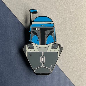 May include: A blue and gray enamel pin featuring a stylized depiction of a Star Wars character, Boba Fett, with a blue helmet and gray armor.