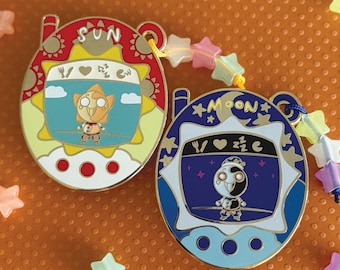 Pin esmaltado de Tamagotchi Sol y Luna que brilla en la oscuridad