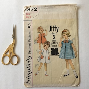 May include: Simplicity sewing pattern number 4872 for a child's dress. The pattern is for a Jiffy dress with two main pattern pieces. The pattern is for a child size 5.
