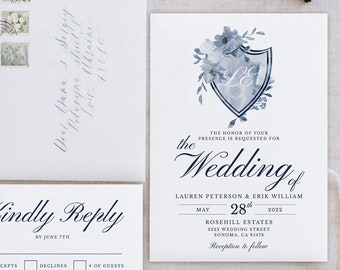 May include: A wedding invitation suite with a blue and white floral design. The invitation features a shield with the initials "LE" in a script font. The RSVP card has a blue and white floral design and the text "Kindly Reply by June 17th". The details card has a blue and white floral design and the text "Details for more wedding weekend details, including accommodations and directions, please visit our wedding website: www.erikloveslauren.wedding.com". The thank you card has a blue and white floral design and the text "Thank you for traveling near and far to be with us on our special day! For the love, support and encouragement you have given us. Thank you for your abundant generosity and your kind gift. We love you and can't wait to celebrate the future with you. Love, The Newlyweds".
