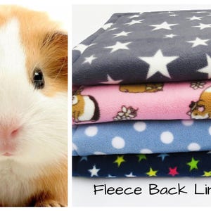 May include: A guinea pig with brown and white fur is shown in a close-up. Stacked fleece back liners in various colours and patterns are shown, including grey with white stars, pink with guinea pig illustrations, blue with white polka dots, and navy with colourful stars.