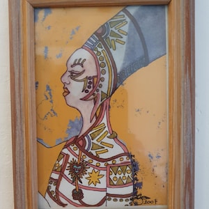 Peut inclure: Une œuvre d'art encadrée représentant le profil d'une personne avec une coiffe élaborée et des vêtements à motifs. L'œuvre est dans un cadre en bois, sur un fond jaune avec des accents bleus et orange. L'œuvre est signée "2007" et porte le texte "Manda Lù Art !!".