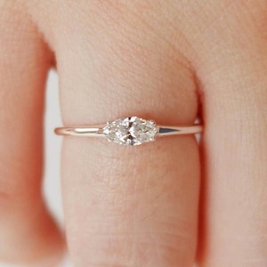 Peut inclure: Une délicate bague en argent avec une seule pierre précieuse ronde et transparente sertie à griffes.