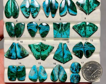 May include: Seventeen pairs of polished, teardrop, triangular, and rectangular malachite and chrysocolla cabochons arranged on a white display tray. Each pair features vibrant blue and green swirling patterns. A US quarter coin is included for scale.