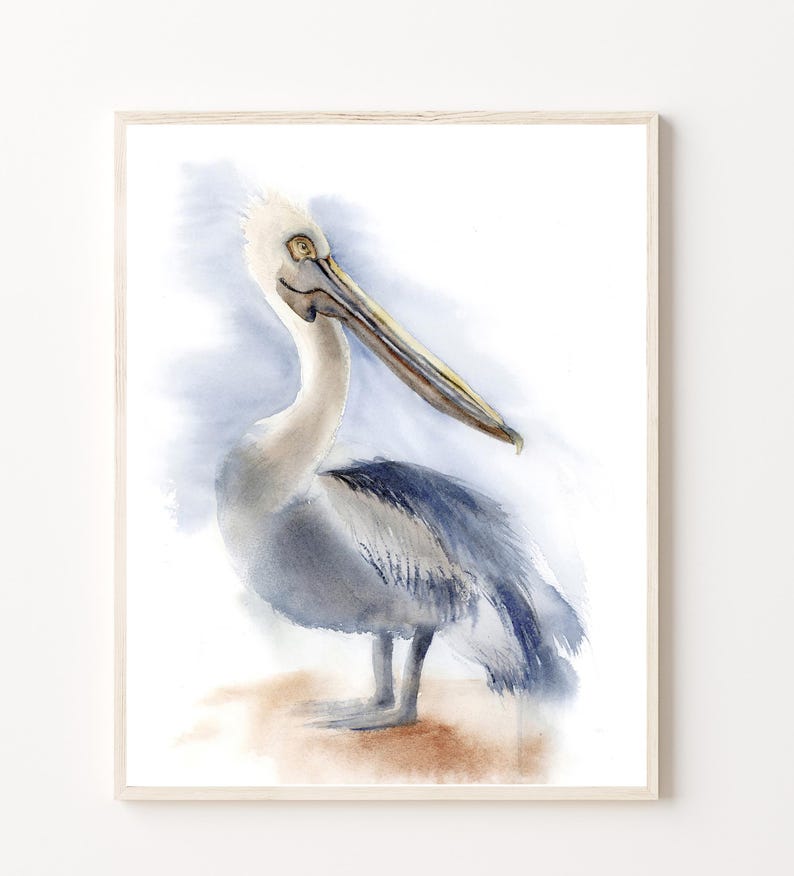 May include: Watercolor painting of a pelican with a long beak and gray and white feathers. The pelican is standing on a sandy beach with a blue and white watercolor background.