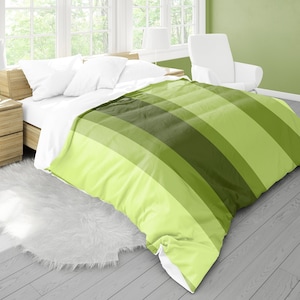 May include: A green and white striped duvet cover on a bed with white pillows. The duvet cover has wide stripes in shades of green.
