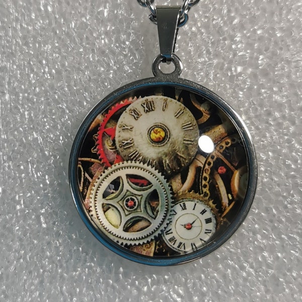 Collier avec pendant cabochon représentant des rouages et une horloge dans un style steampunk