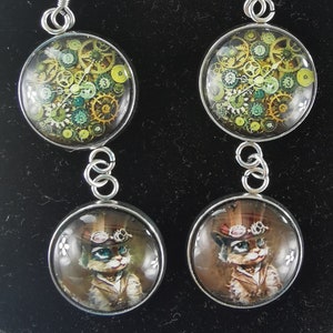 Paar oorbellen dubbele cabochons tandwiel en steampunk kat met hoed en bril