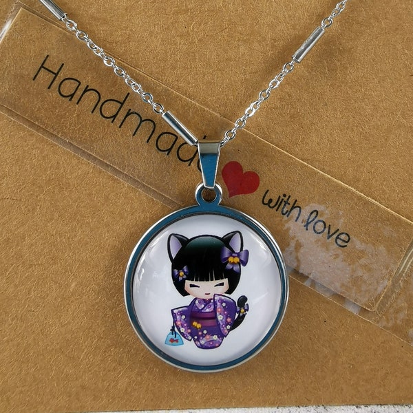 Collier kokeshi au kimono mauve avec oreilles et queue de chat sur un fonds blanc