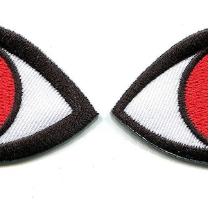 May include: Two embroidered patches shaped like eyes, each featuring a white sclera, a vibrant red iris, and a solid black pupil, all outlined with a thick black stitched border on a white background.