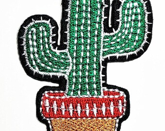 May include: An embroidered patch featuring a green cactus with white stitched details and small spikes. The cactus is planted in a pot with a red rim and a textured tan base, all outlined with a thick black border on a white background.