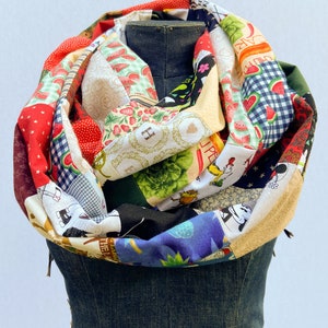 May include: A colorful patchwork infinity scarf with various patterns, including watermelon, strawberries, Mickey Mouse, and stars. The scarf is made of cotton fabric and is a great accessory for any outfit.