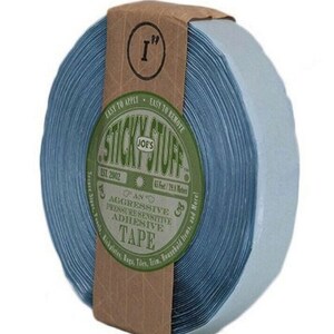 May include: A roll of blue 1-inch wide adhesive tape with a brown label that reads "Joe's Sticky Stuff" and "An Aggressive Pressure Sensitive Adhesive Tape".