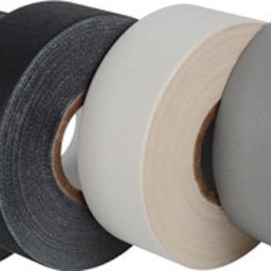 May include: Five rolls of athletic tape, two black, one white, and two gray. The tape is 1.5 inches wide and is designed for use in sports and physical activities.