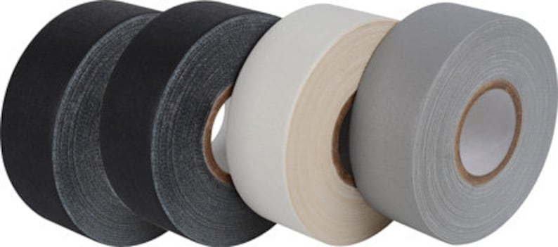 May include: Five rolls of athletic tape, two black, one white, and two gray. The tape is 1.5 inches wide and is designed for use in sports and physical activities.