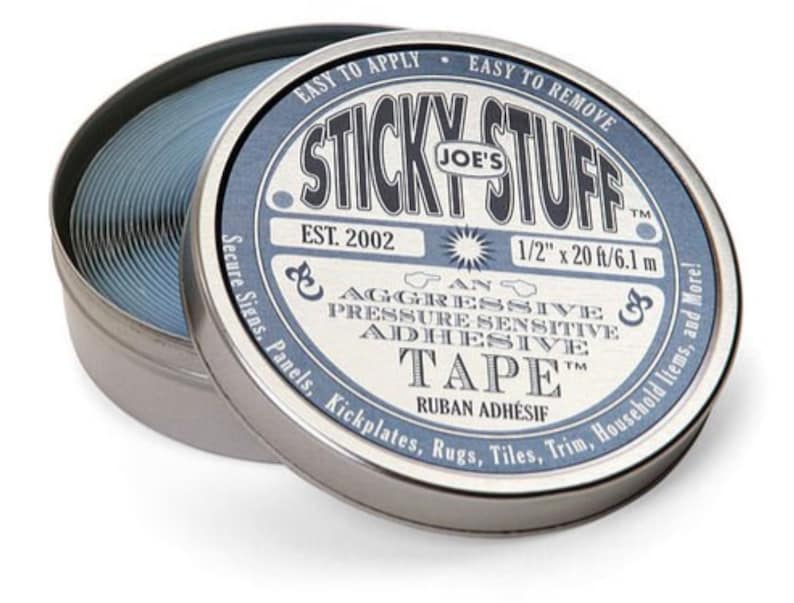 May include: A round tin container with a blue and white label that reads "Sticky Stuff Joe's Est. 2002" and "An Aggressive Pressure Sensitive Adhesive Tape 1/2" x 20 ft/6.1 m". The tin contains a roll of blue tape.