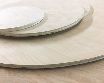 May include: Three round wooden discs stacked on top of each other. The discs are made of light-colored wood and have a smooth, polished surface.