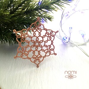 May include: A delicate copper-colored snowflake ornament with intricate details, perfect for adding a touch of elegance to your holiday decor.