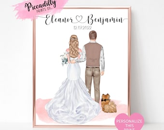May include: A framed print featuring a bride and groom with a small dog. The bride wears a white wedding dress, and the groom wears a brown vest. The print includes the names "Eleanor" and "Benjamin" with the date "12.07.2022".