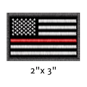 May include: Embroidered patch featuring a stylized American flag design with a red stripe. The patch measures 2 inches by 3 inches and has a black border. The flag's stars are white, and the stripes alternate between white and black.
