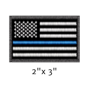 May include: Embroidered patch featuring the American flag design with a blue line. The patch measures 2 inches by 3 inches. The flag has white stars on a blue background, with white and black stripes, and a blue stripe.