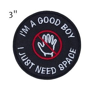 May include: A round, black embroidered patch with white text that reads "I'M A GOOD BOY I JUST NEED SPACE." A red circle with a line through a white hand graphic is in the center. The patch is 3 inches in diameter.