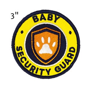 May include: Embroidered patch, 3 inches in diameter, with the words "BABY SECURITY GUARD". The patch features a yellow border, navy blue text and accents, and an orange shield with a white paw print.