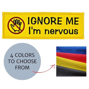 May include: Yellow patch with the text "IGNORE ME I'm nervous" and a red hand with a line through it. The image also shows a circle with the text "4 COLORS TO CHOOSE FROM" and a swatch of fabric in blue, red, yellow, and black.