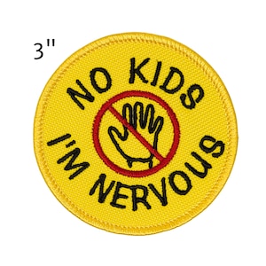 May include: A round, yellow embroidered patch with the text "NO KIDS I'M NERVOUS" in black. A red circle with a line through a hand graphic is in the center. The patch is 3 inches in diameter.