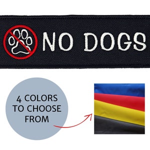 May include: A black rectangular patch with white embroidered text reading "NO DOGS". A red circle with a paw print and a slash through it is above the text. The image also shows a color palette with four color options.